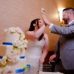 A bride and groom cutting their wedding cake.