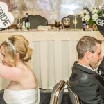 A bride and groom sitting at the head table.