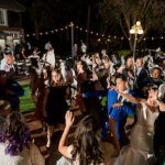 A group of people dancing in the middle of an outdoor party.