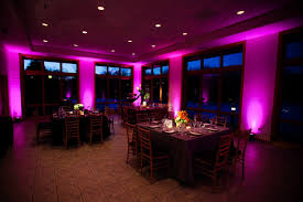 A room with purple lighting and tables in it