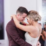 A man and woman are dancing together at their wedding.