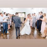 A bride and groom are dancing at their wedding.